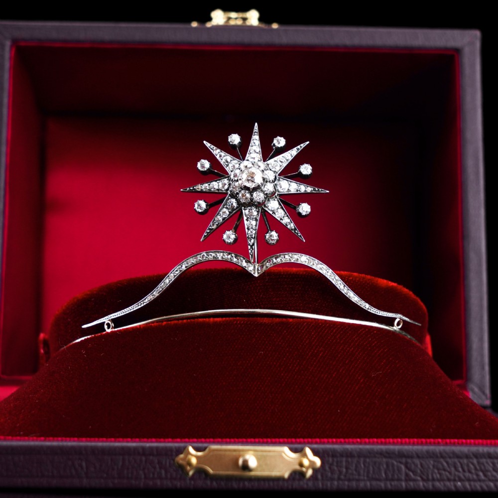 A Victorian diamond starburst tiara featuring a central starburst motif set with round cut diamonds above a sweeping diamond arch mounted on a fine metal headband. View VII