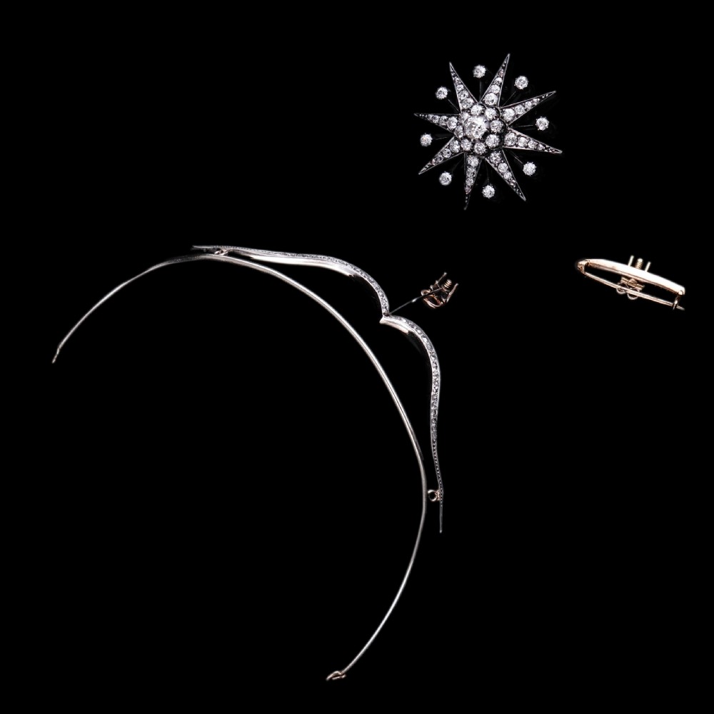 A Victorian diamond starburst tiara featuring a central starburst motif set with round cut diamonds above a sweeping diamond arch mounted on a fine metal headband. View IX