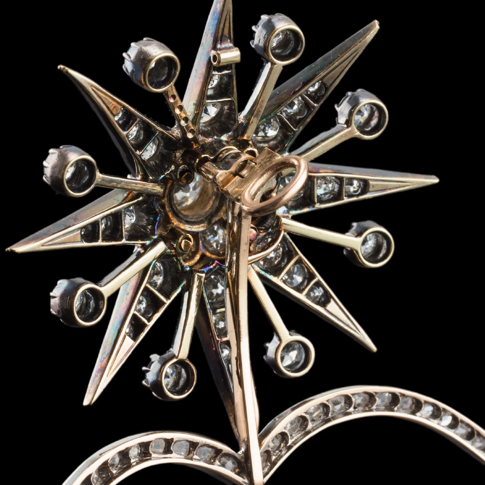 A Victorian diamond starburst tiara featuring a central starburst motif set with round cut diamonds above a sweeping diamond arch mounted on a fine metal headband. View X