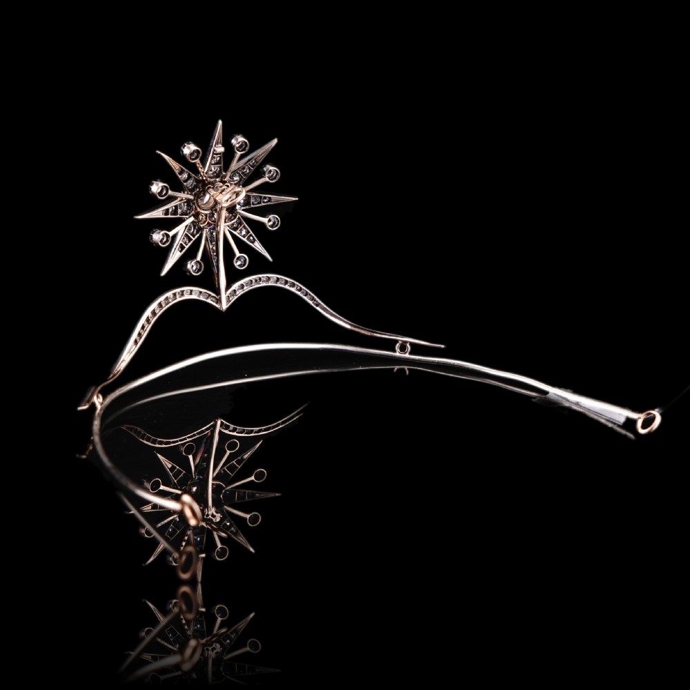 A Victorian diamond starburst tiara featuring a central starburst motif set with round cut diamonds above a sweeping diamond arch mounted on a fine metal headband. View XII