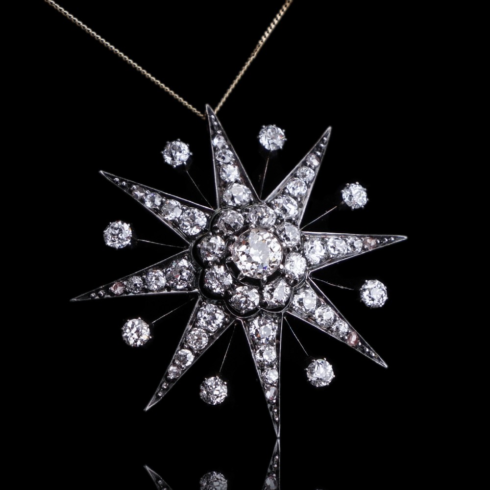 A Victorian diamond starburst tiara featuring a central starburst motif set with round cut diamonds above a sweeping diamond arch mounted on a fine metal headband. View XIX