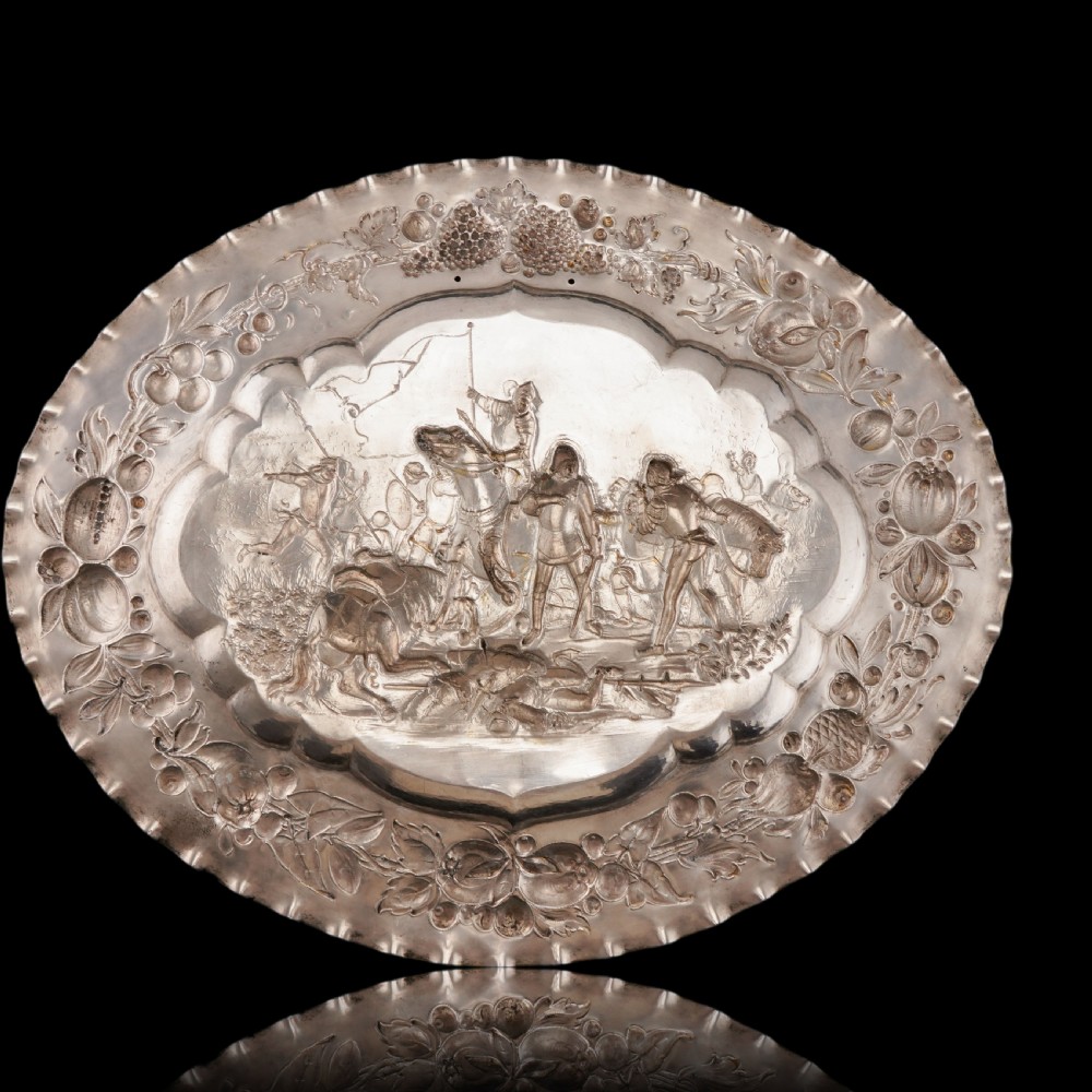 An oval 19th-century solid silver gilt charger dish featuring a central raised relief of a battle scene surrounded by embossed fruit borders. View VIII