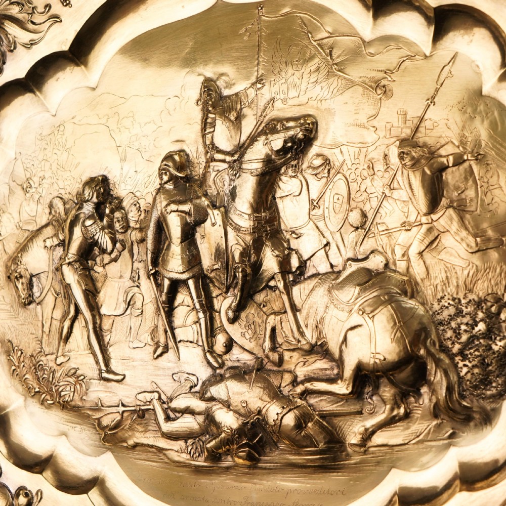 An oval 19th-century solid silver gilt charger dish featuring a central raised relief of a battle scene surrounded by embossed fruit borders. View XIV