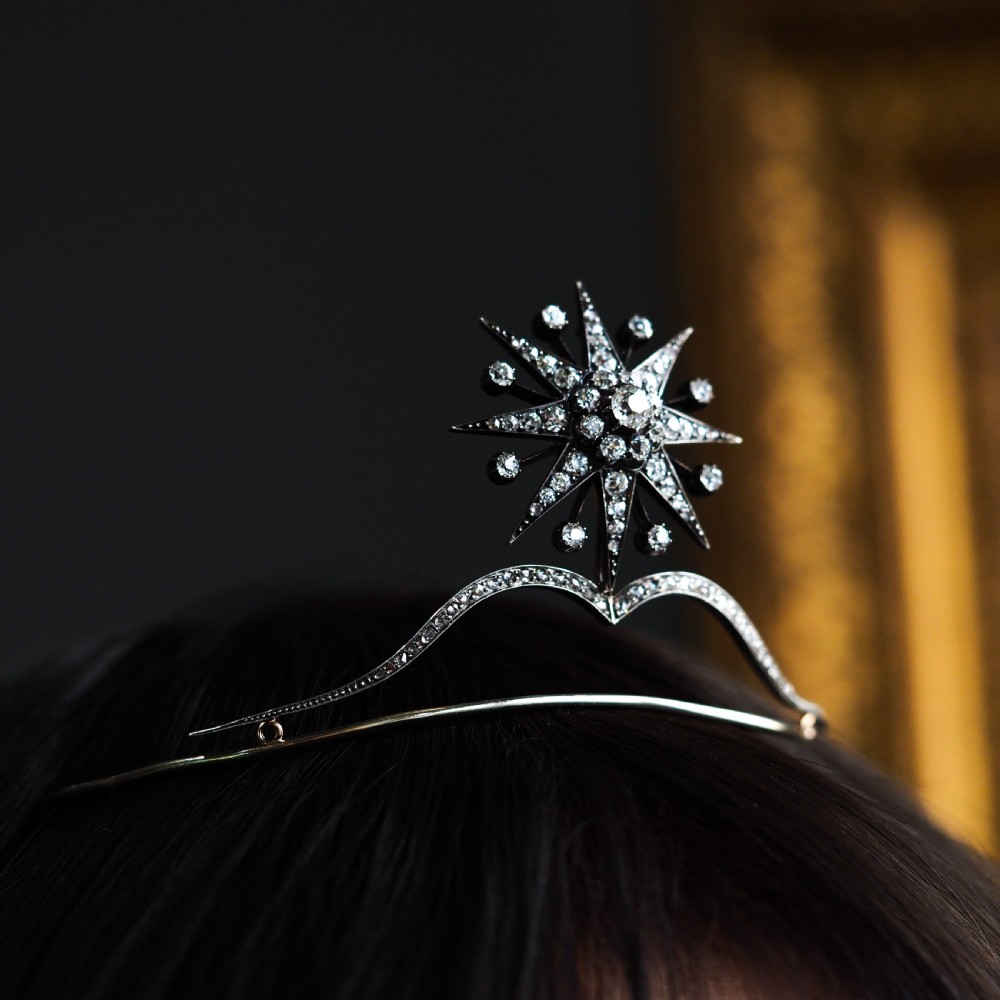 A Victorian diamond starburst tiara featuring a central starburst motif set with round cut diamonds above a sweeping diamond arch mounted on a fine metal headband. View XXI