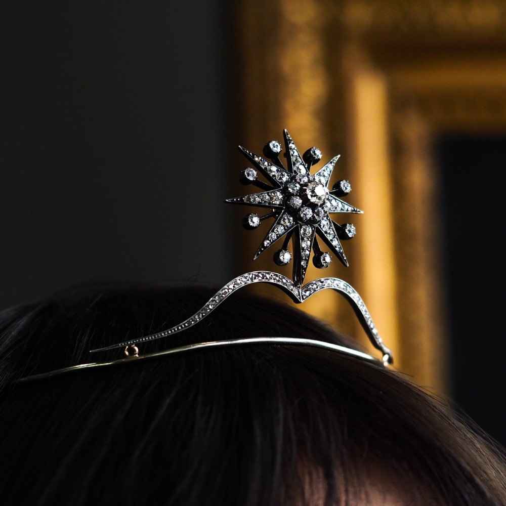 A Victorian diamond starburst tiara featuring a central starburst motif set with round cut diamonds above a sweeping diamond arch mounted on a fine metal headband. View XXII
