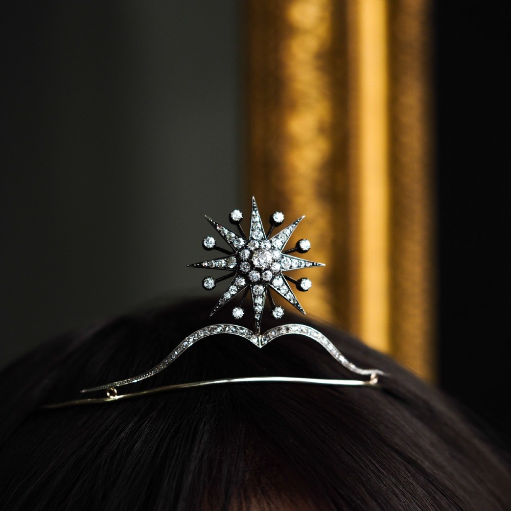 A Victorian diamond starburst tiara featuring a central starburst motif set with round cut diamonds above a sweeping diamond arch mounted on a fine metal headband. View XXIII