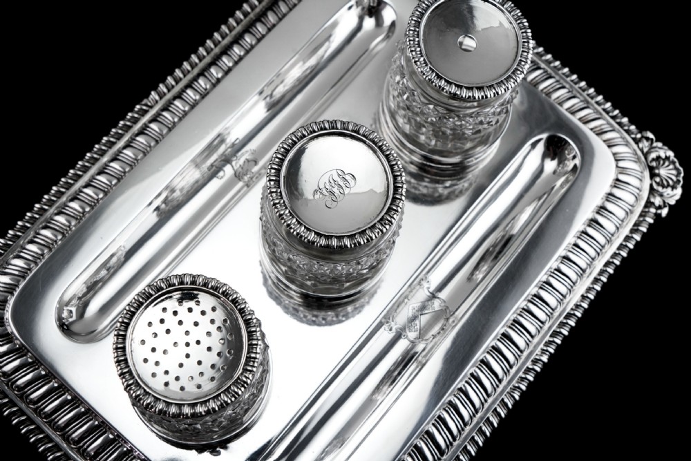 A rectangular Regency sterling silver inkstand featuring gadrooned borders, shell corners, two pen depressions, and three cut glass pots with silver lids. View VII