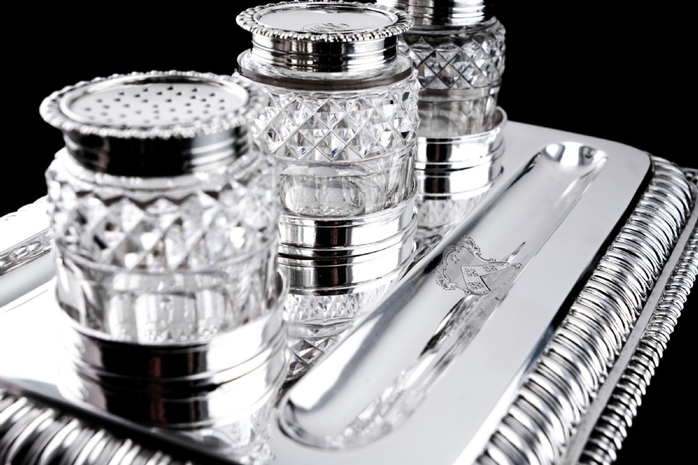 A rectangular Regency sterling silver inkstand featuring gadrooned borders, shell corners, two pen depressions, and three cut glass pots with silver lids. View IX