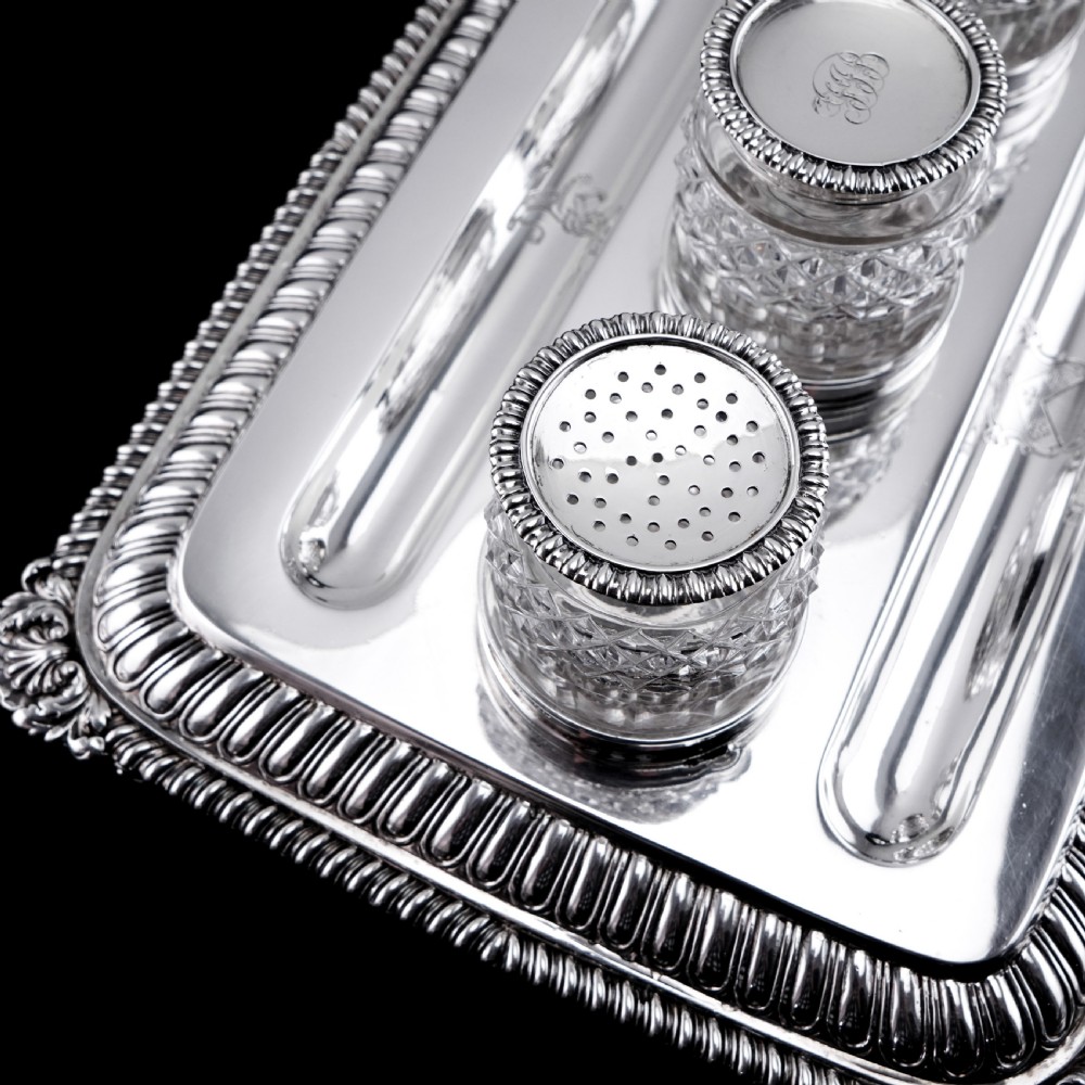A rectangular Regency sterling silver inkstand featuring gadrooned borders, shell corners, two pen depressions, and three cut glass pots with silver lids. View XII