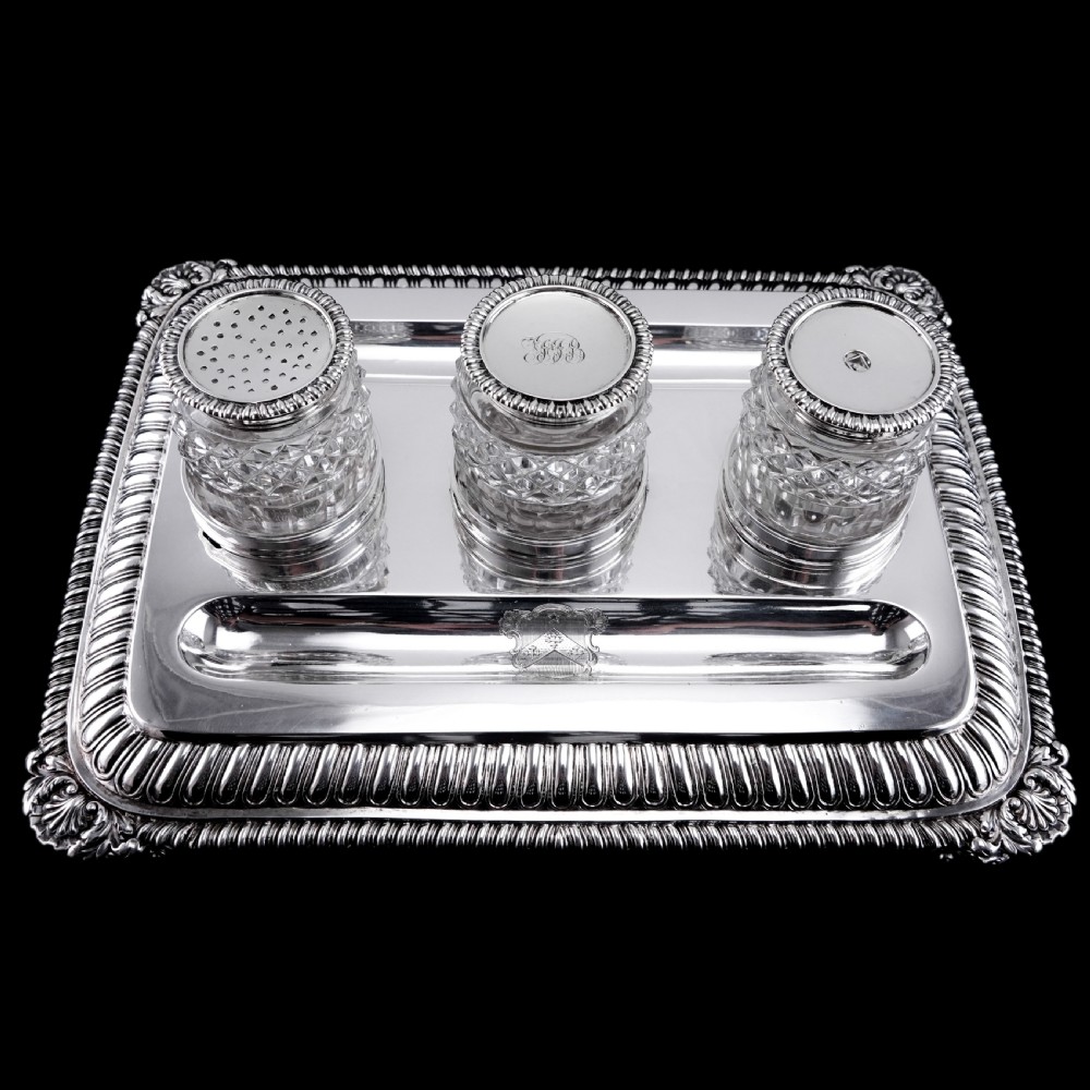 A rectangular Regency sterling silver inkstand featuring gadrooned borders, shell corners, two pen depressions, and three cut glass pots with silver lids. View XIII