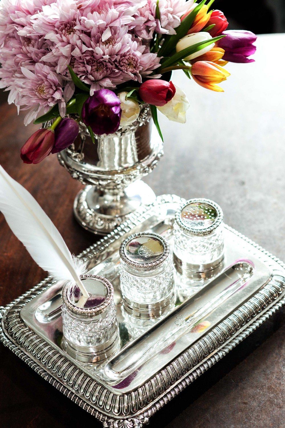 A rectangular Regency sterling silver inkstand featuring gadrooned borders, shell corners, two pen depressions, and three cut glass pots with silver lids. View XXXI