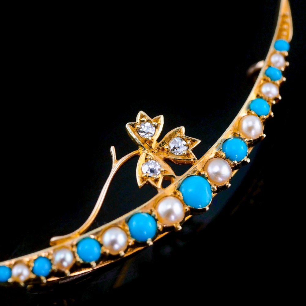 A Victorian 15ct yellow gold crescent brooch set with alternating turquoise cabochons and split pearls, featuring an offset diamond trefoil motif. View V