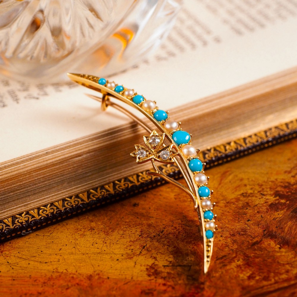 A Victorian 15ct yellow gold crescent brooch set with alternating turquoise cabochons and split pearls, featuring an offset diamond trefoil motif. View VII