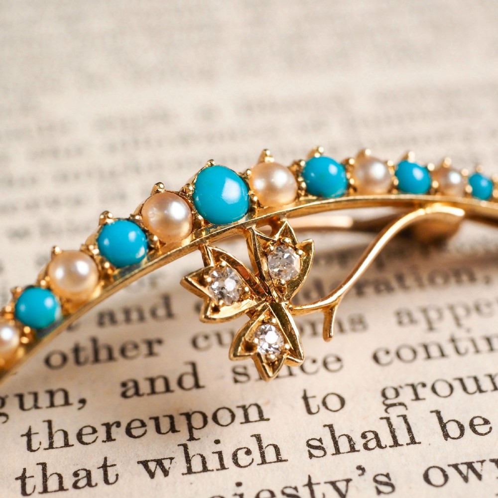 A Victorian 15ct yellow gold crescent brooch set with alternating turquoise cabochons and split pearls, featuring an offset diamond trefoil motif. View VIII