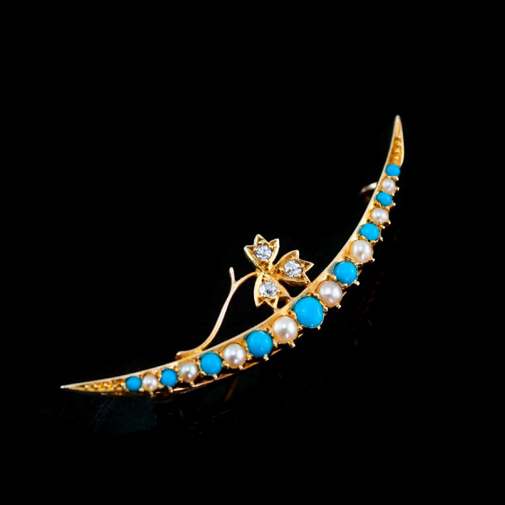 A Victorian 15ct yellow gold crescent brooch set with alternating turquoise cabochons and split pearls, featuring an offset diamond trefoil motif.