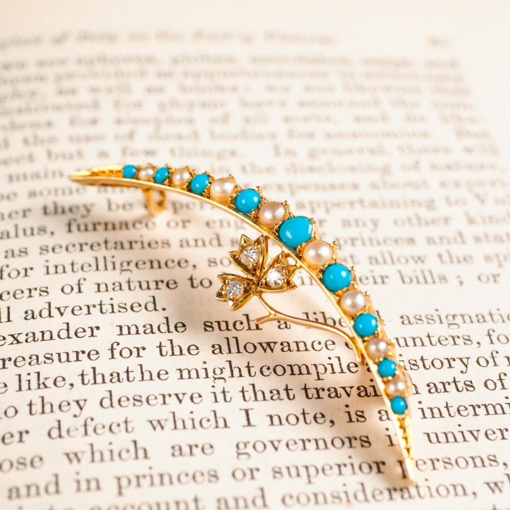 A Victorian 15ct yellow gold crescent brooch set with alternating turquoise cabochons and split pearls, featuring an offset diamond trefoil motif. View X