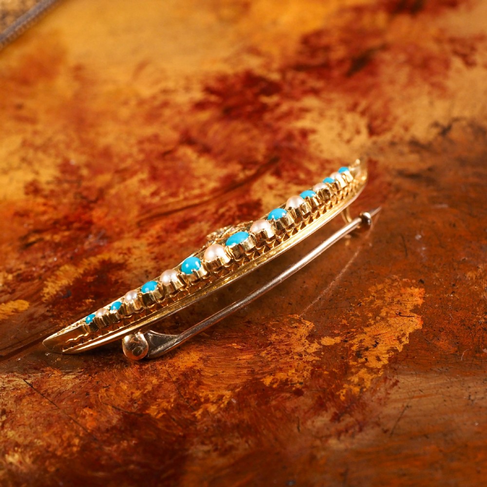 A Victorian 15ct yellow gold crescent brooch set with alternating turquoise cabochons and split pearls, featuring an offset diamond trefoil motif. View XI
