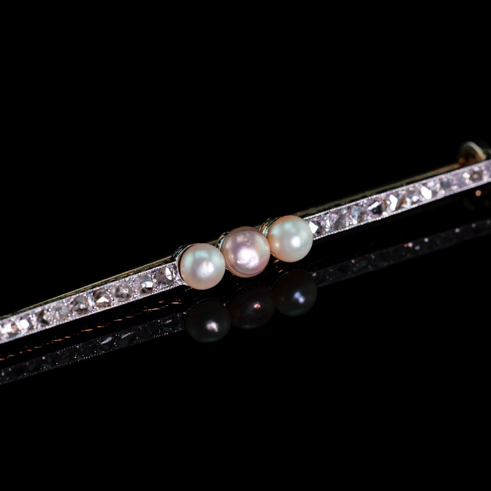 An antique 18ct gold and platinum bar brooch featuring three central pearls flanked by a row of small diamonds. View XIII