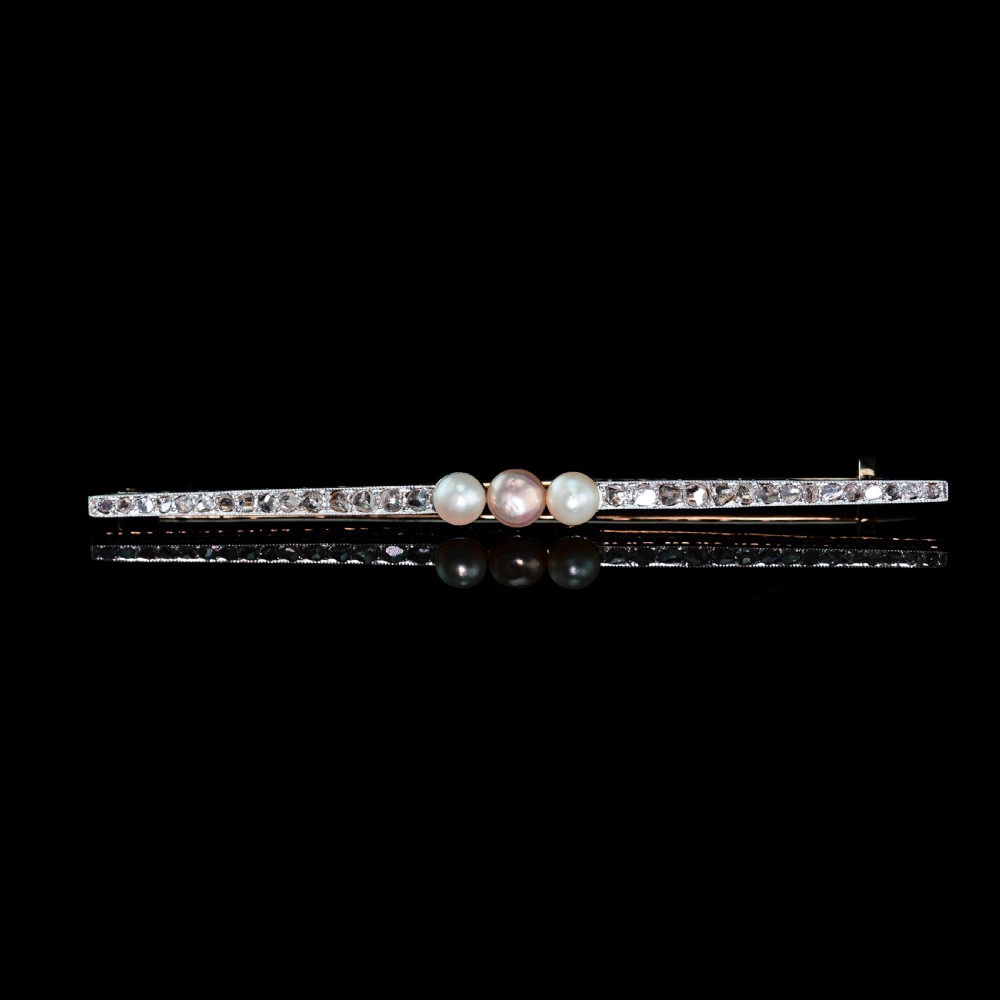 An antique 18ct gold and platinum bar brooch featuring three central pearls flanked by a row of small diamonds. View XVII