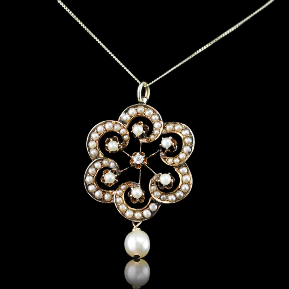 A Victorian 14ct yellow gold circular scrollwork pendant set with seed pearls, a central diamond, and an articulated pearl drop suspended from a fine chain. View III