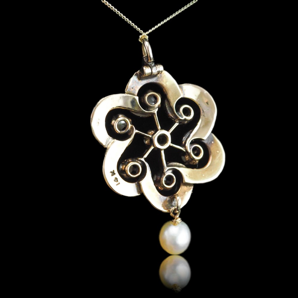 A Victorian 14ct yellow gold circular scrollwork pendant set with seed pearls, a central diamond, and an articulated pearl drop suspended from a fine chain. View XVII