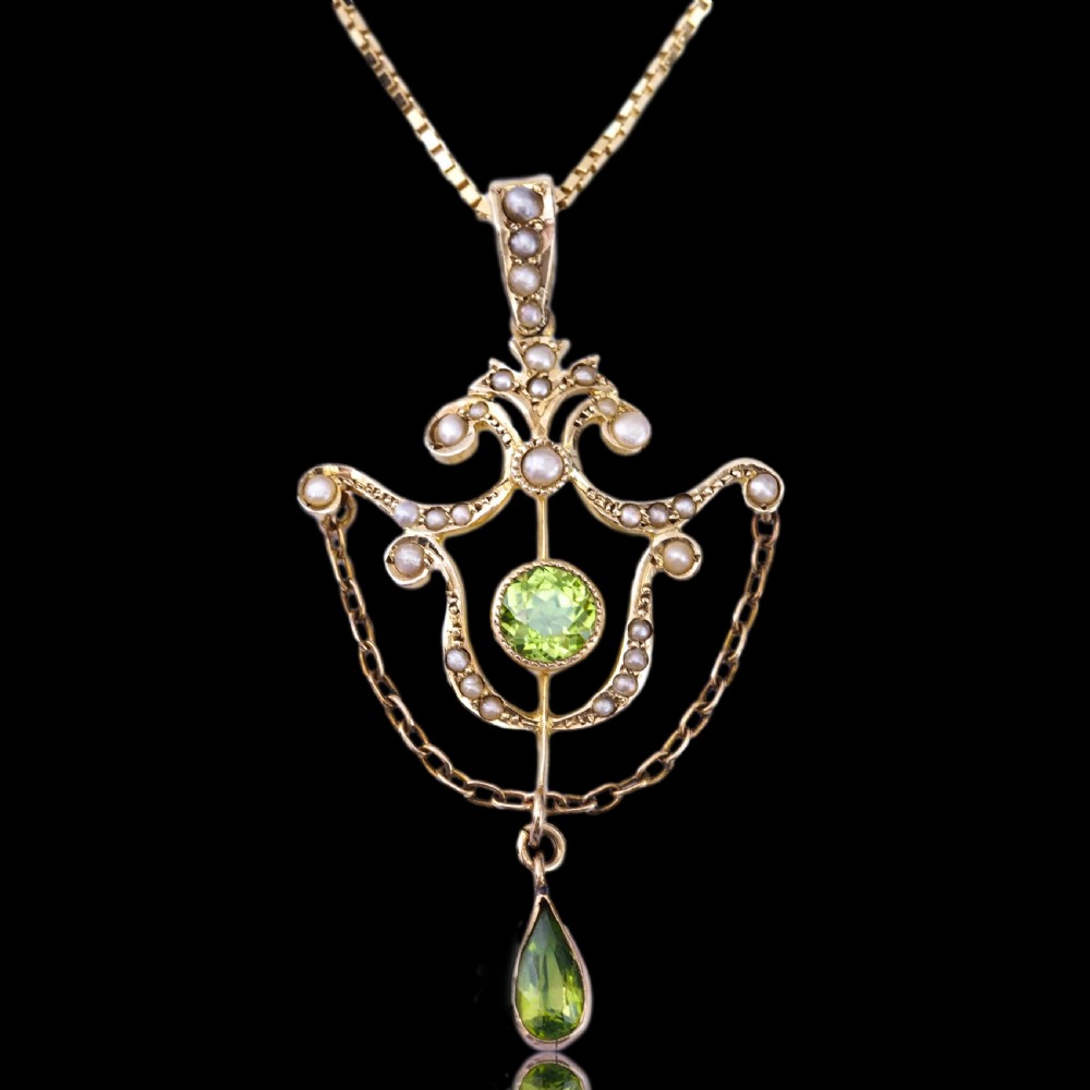 An Edwardian 9ct gold openwork pendant set with seed pearls, a central round peridot, and a dangling teardrop peridot. View II