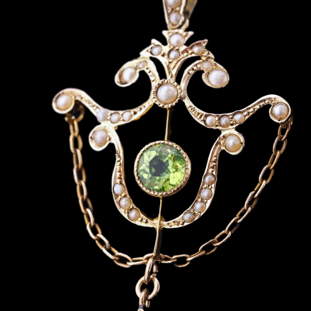 An Edwardian 9ct gold openwork pendant set with seed pearls, a central round peridot, and a dangling teardrop peridot. View III