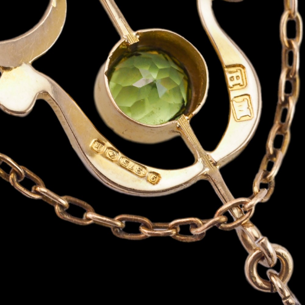An Edwardian 9ct gold openwork pendant set with seed pearls, a central round peridot, and a dangling teardrop peridot. View XV