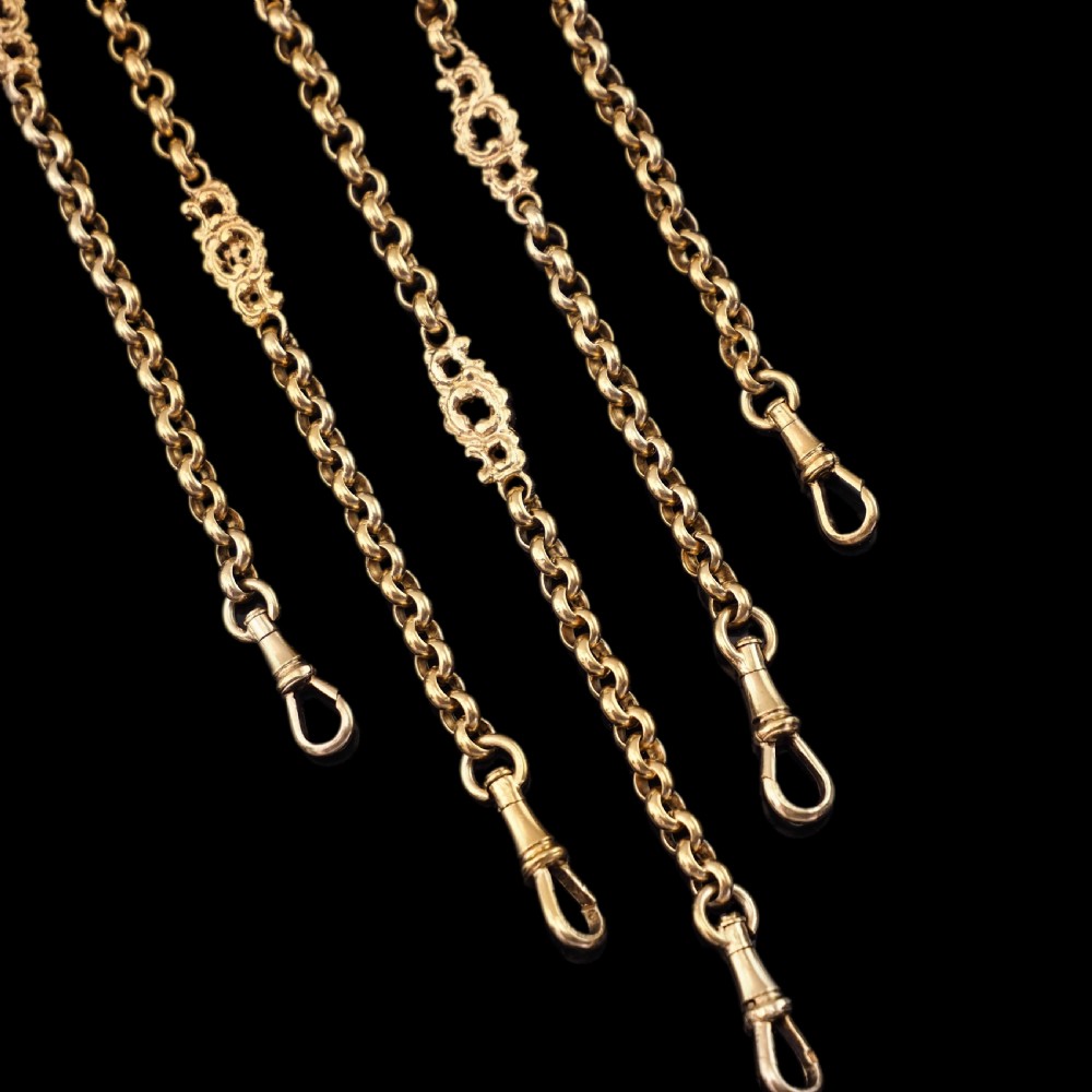 An ornate Victorian silver-gilt chatelaine featuring five hanging chains with swivel clips and a rococo plaque detailed with a central cherub motif. View III