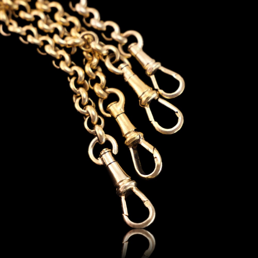 An ornate Victorian silver-gilt chatelaine featuring five hanging chains with swivel clips and a rococo plaque detailed with a central cherub motif. View XX