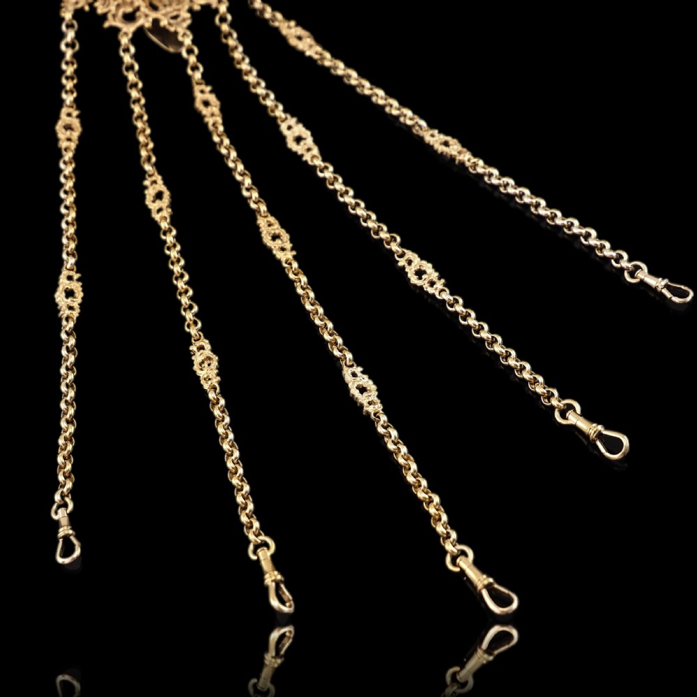 An ornate Victorian silver-gilt chatelaine featuring five hanging chains with swivel clips and a rococo plaque detailed with a central cherub motif. View XXX