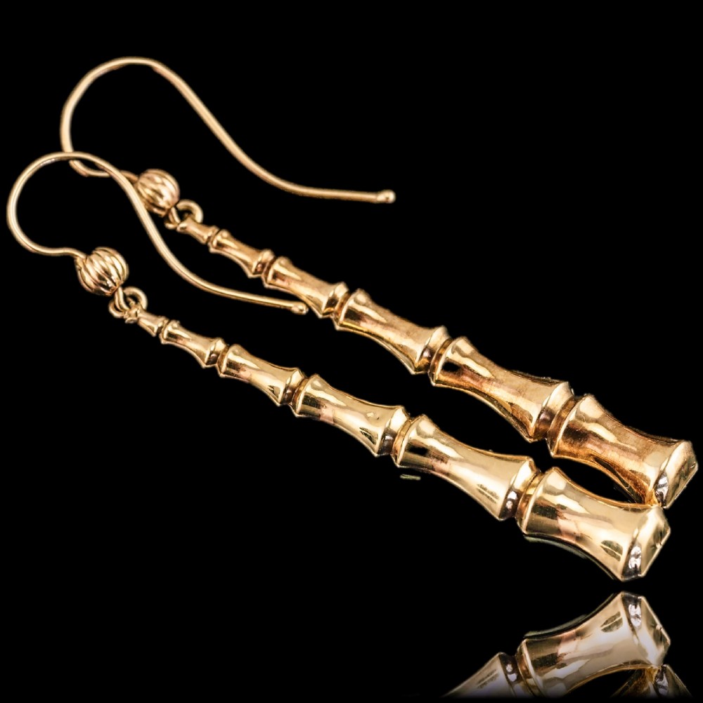 A pair of 9ct yellow gold drop earrings designed with stacked bamboo node motifs hanging from shepherd hook ear wires. View II