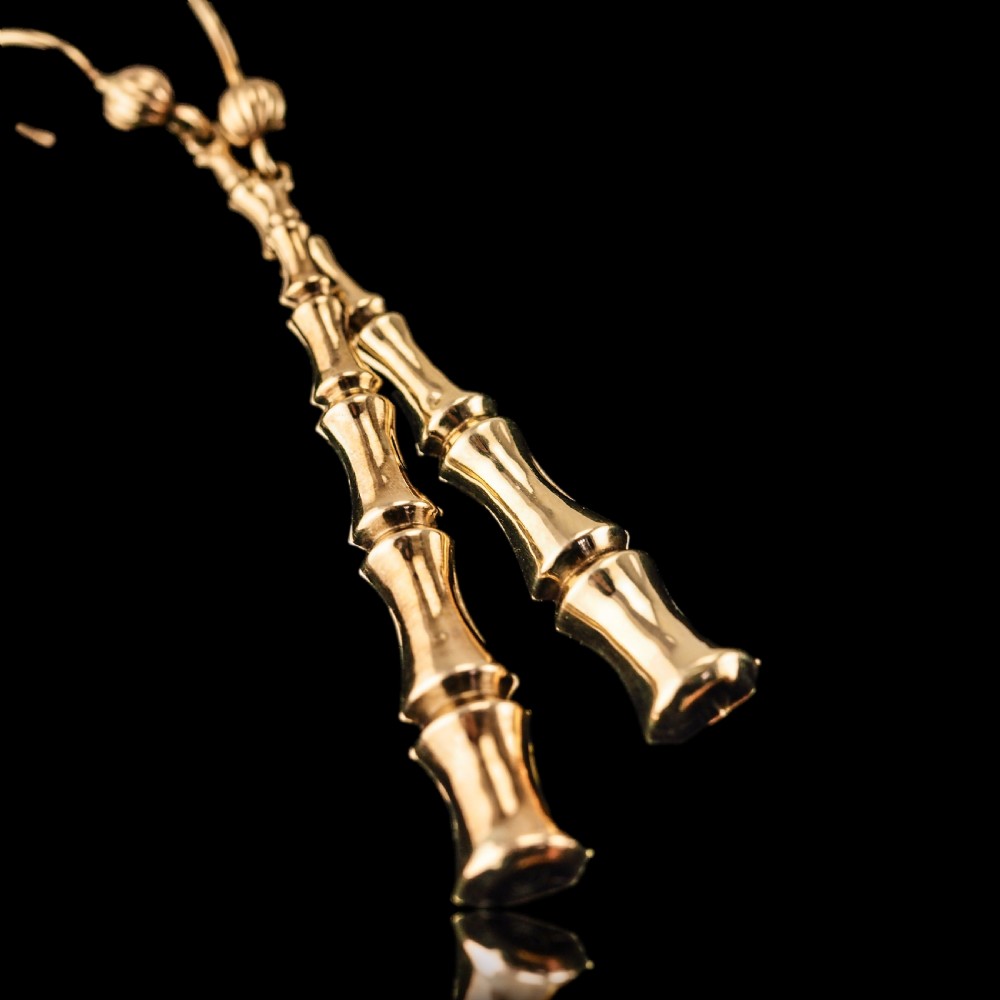 A pair of 9ct yellow gold drop earrings designed with stacked bamboo node motifs hanging from shepherd hook ear wires. View XVI