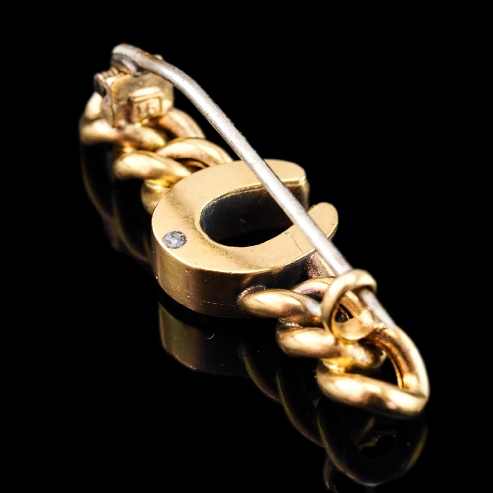 An antique 15ct gold bar brooch featuring a central horseshoe motif set with seed pearls over a curb link design. View III