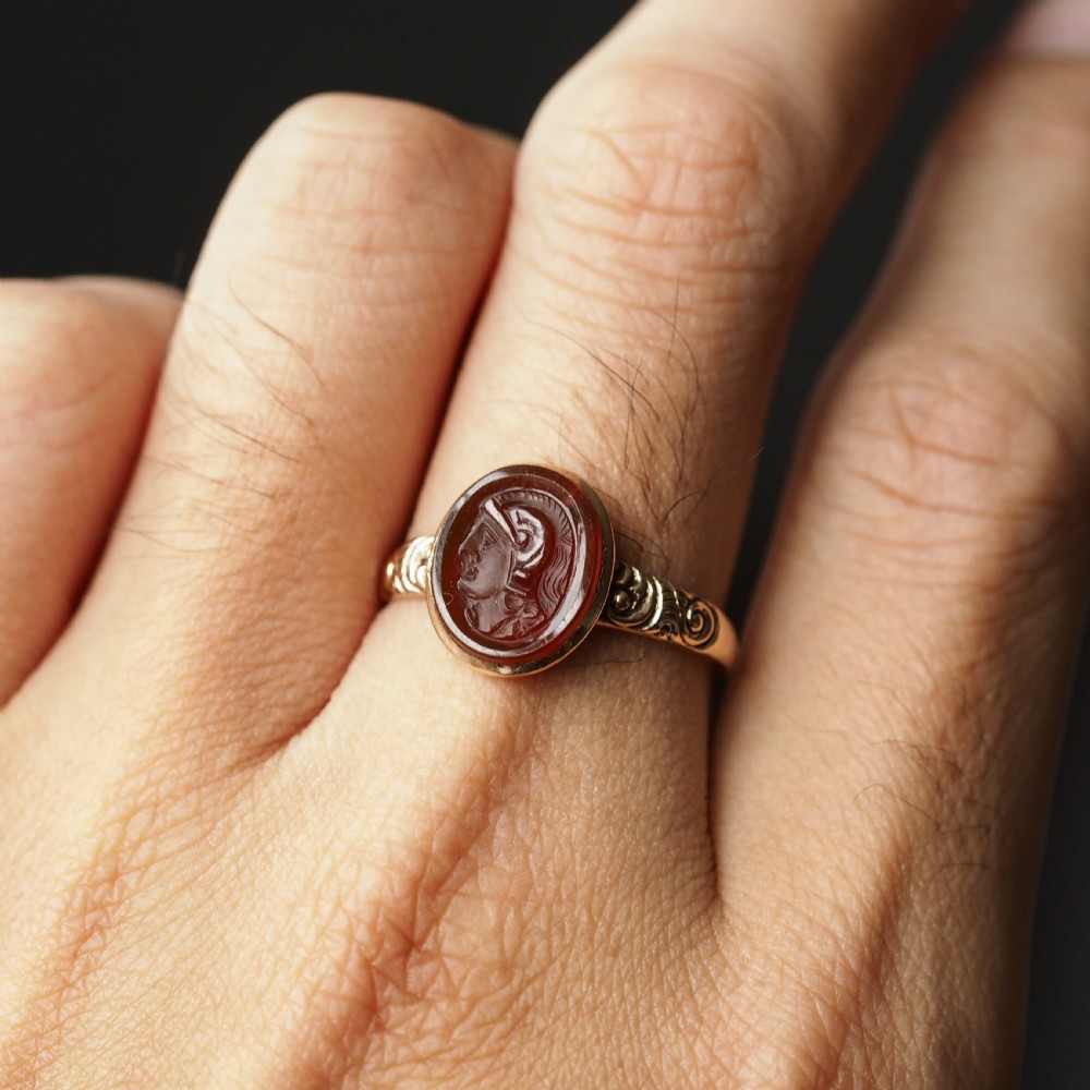 A Georgian gold ring featuring an oval reddish-brown carnelian stone engraved with the profile profile of a helmeted Roman soldier. View V