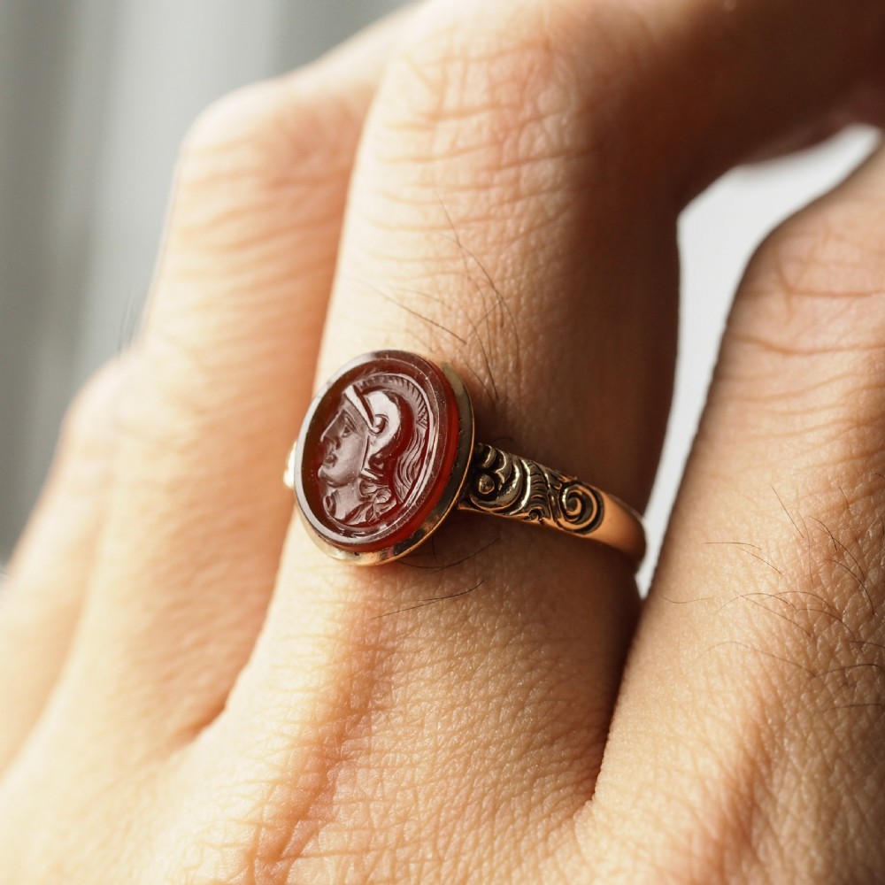 A Georgian gold ring featuring an oval reddish-brown carnelian stone engraved with the profile profile of a helmeted Roman soldier. View VII