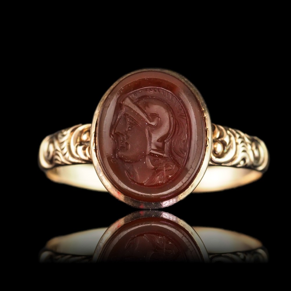 A Georgian gold ring featuring an oval reddish-brown carnelian stone engraved with the profile profile of a helmeted Roman soldier. View XII