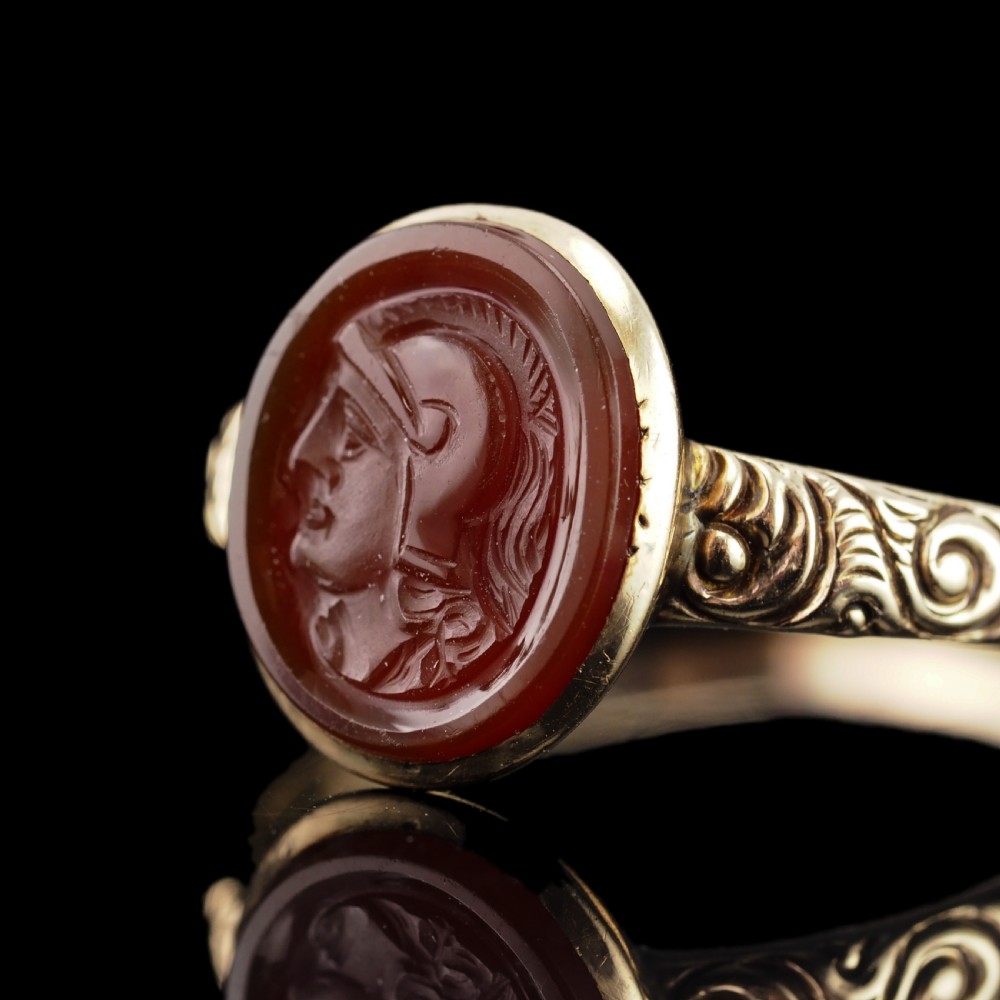 A Georgian gold ring featuring an oval reddish-brown carnelian stone engraved with the profile profile of a helmeted Roman soldier. View XIII