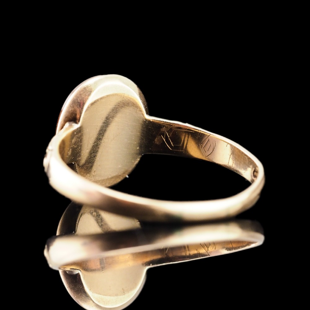 A Georgian gold ring featuring an oval reddish-brown carnelian stone engraved with the profile profile of a helmeted Roman soldier. View XV