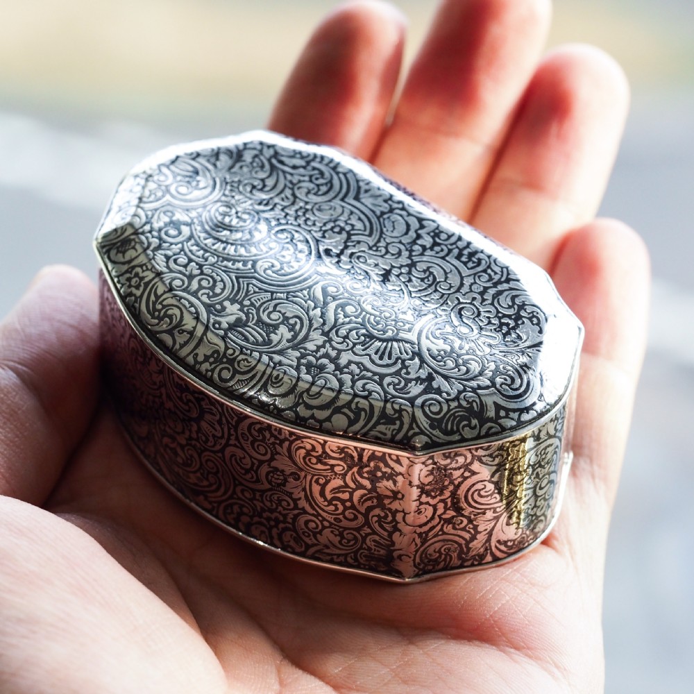 An antique French solid silver snuff box with black niello scrollwork engraving and a gilded gold interior. View II