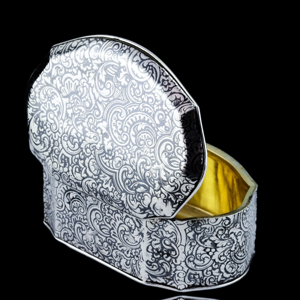 An antique French solid silver snuff box with black niello scrollwork engraving and a gilded gold interior. View V