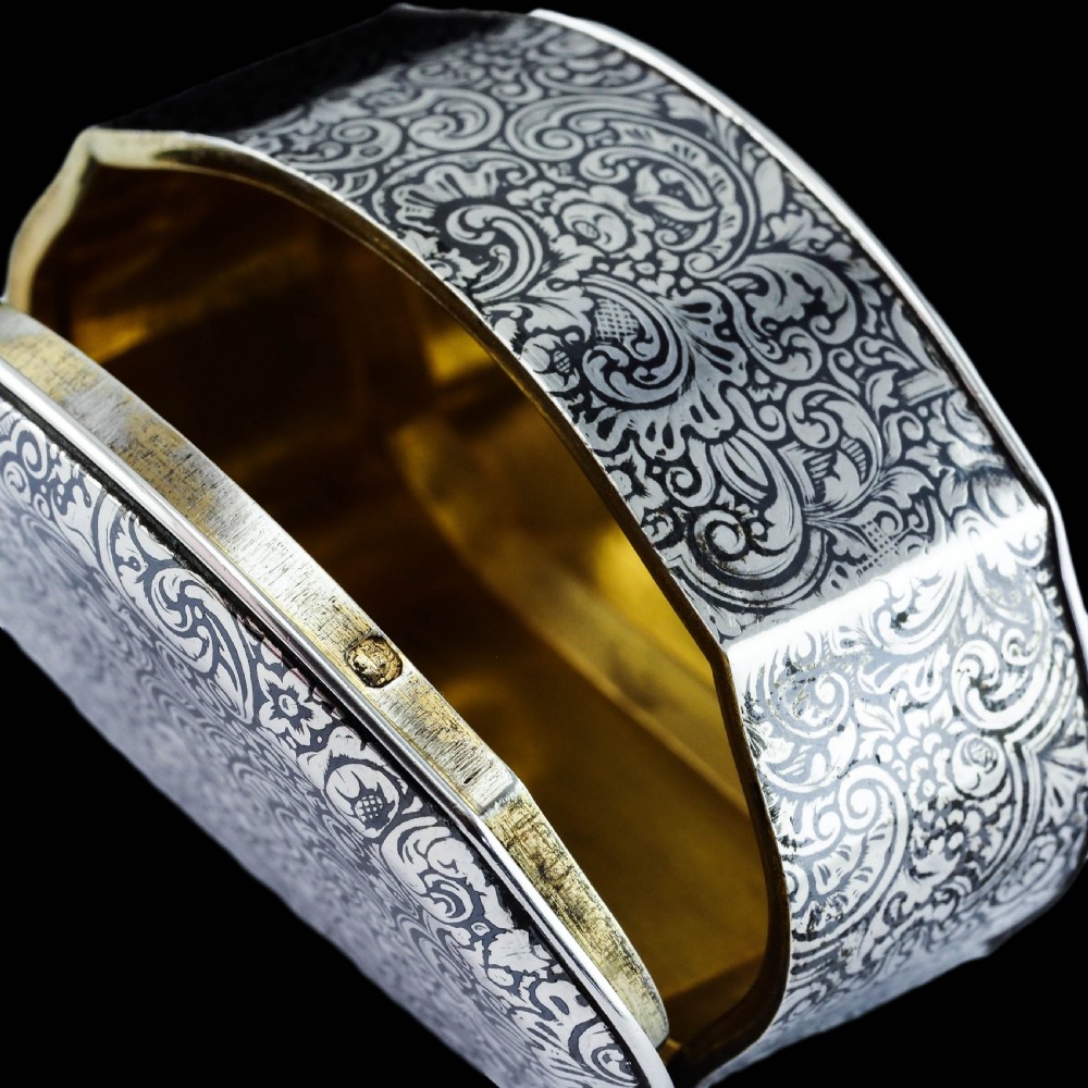 An antique French solid silver snuff box with black niello scrollwork engraving and a gilded gold interior. View VI