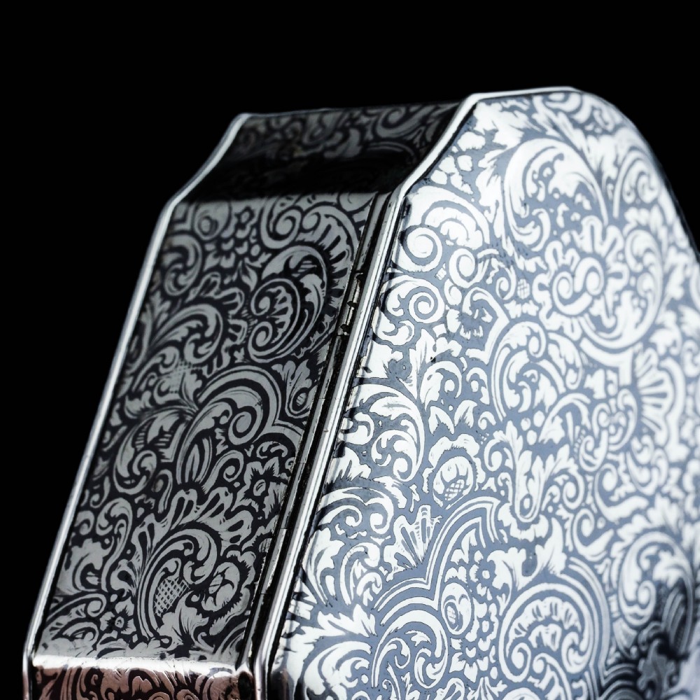An antique French solid silver snuff box with black niello scrollwork engraving and a gilded gold interior. View IX