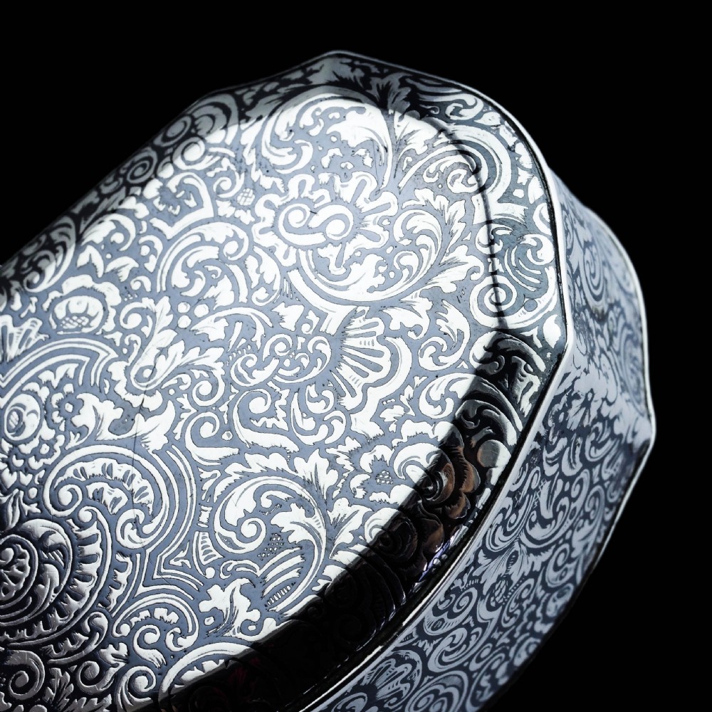 An antique French solid silver snuff box with black niello scrollwork engraving and a gilded gold interior. View X