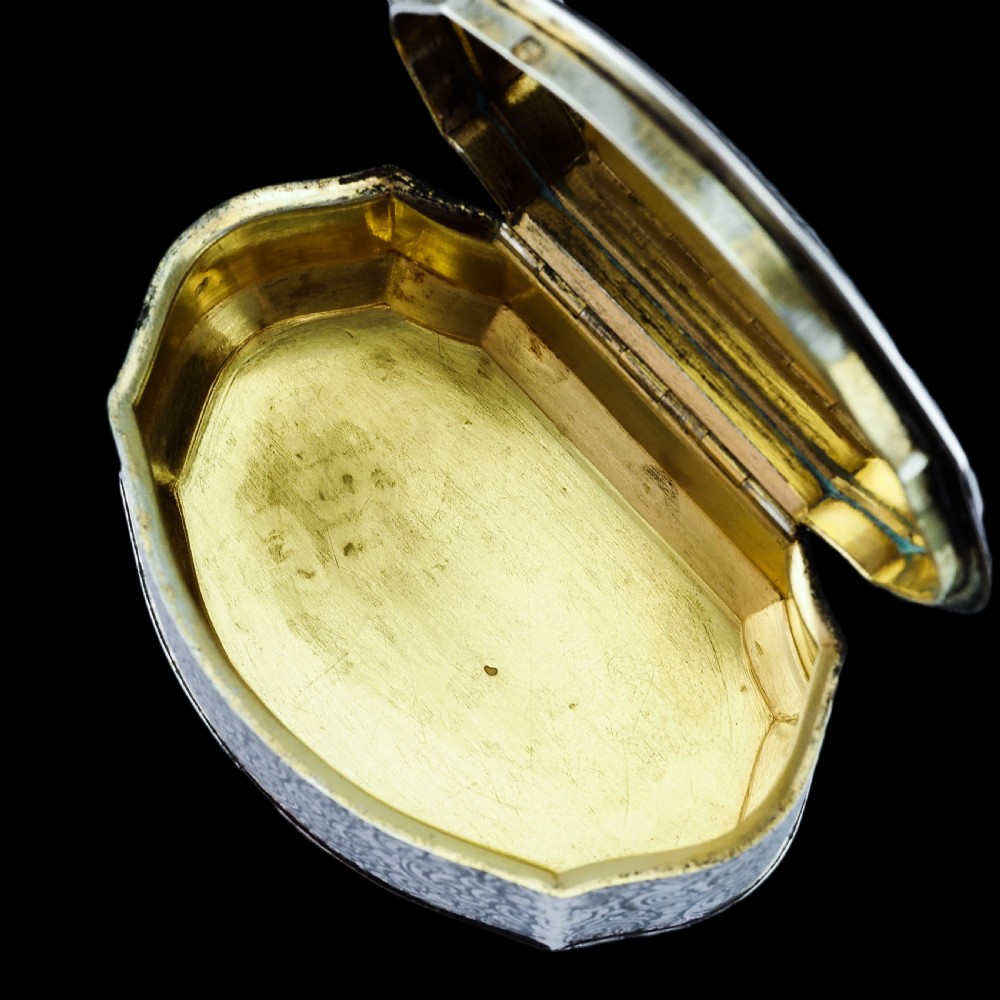 An antique French solid silver snuff box with black niello scrollwork engraving and a gilded gold interior. View XIV