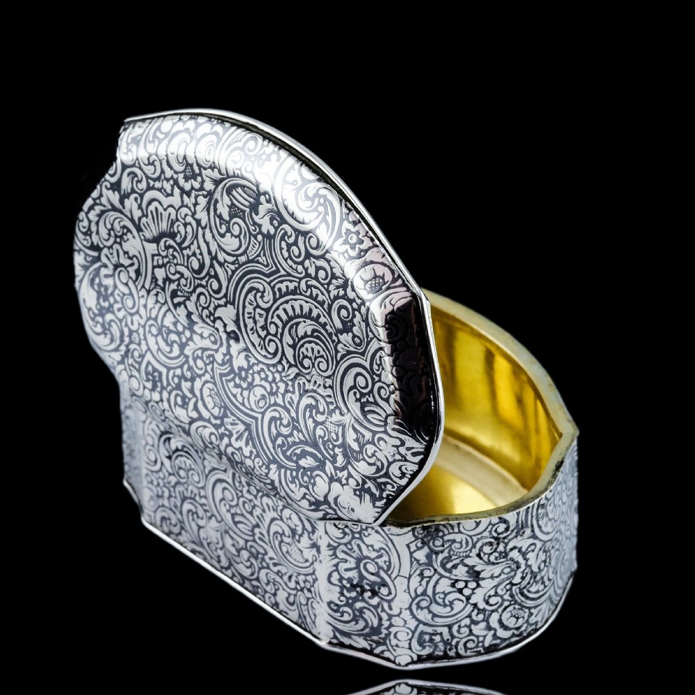An antique French solid silver snuff box with black niello scrollwork engraving and a gilded gold interior. View XVII