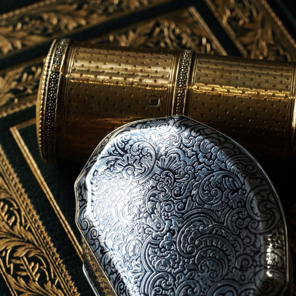An antique French solid silver snuff box with black niello scrollwork engraving and a gilded gold interior. View XXVIII