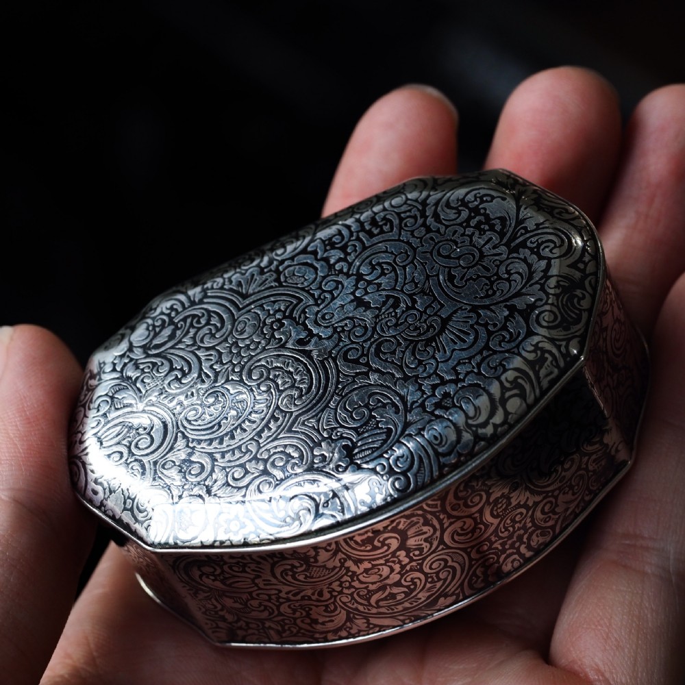 An antique French solid silver snuff box with black niello scrollwork engraving and a gilded gold interior. View XXX