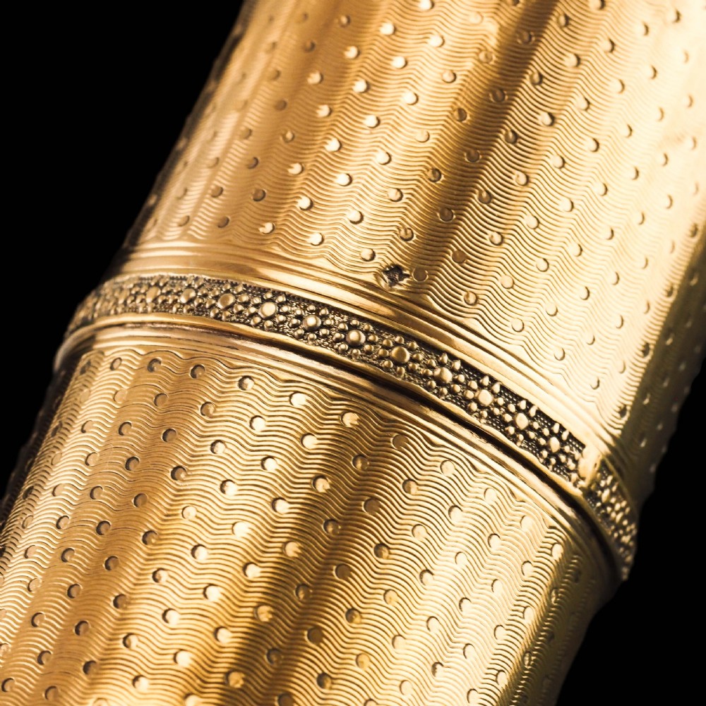 A small cylindrical French silver gilt etui featuring intricate engine-turned guilloche wave patterns and textured borders. View VIII