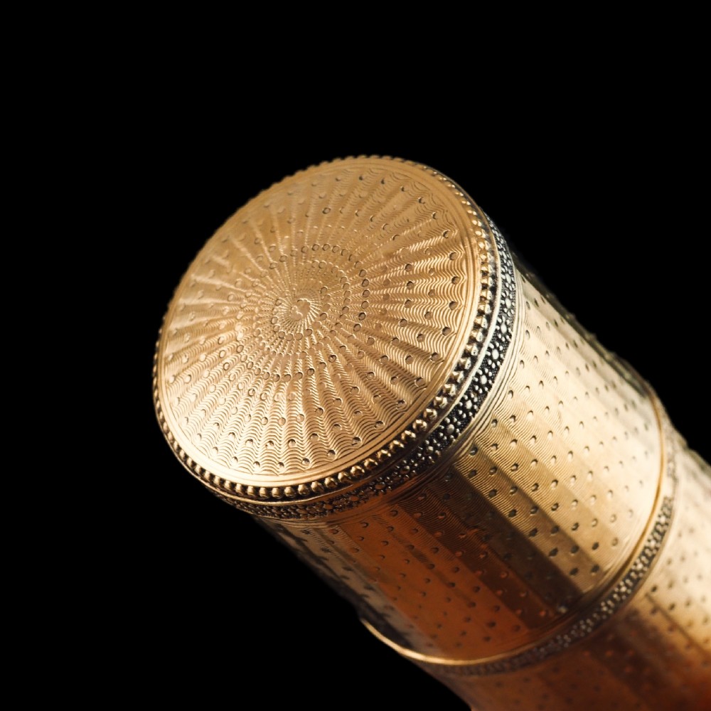 A small cylindrical French silver gilt etui featuring intricate engine-turned guilloche wave patterns and textured borders. View IX